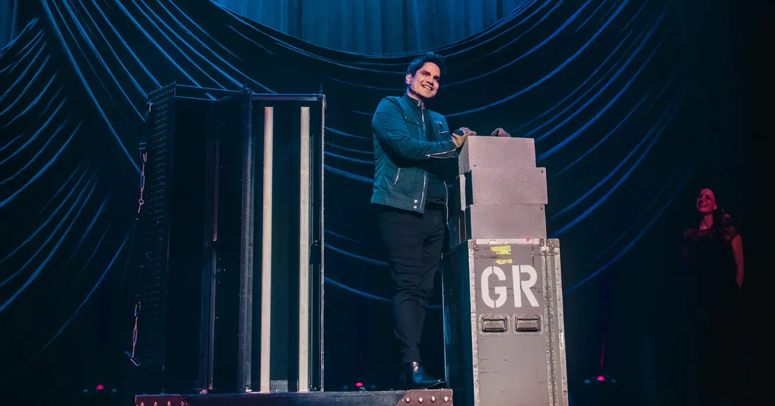 Jason Bishop on stage in front of a black curtain